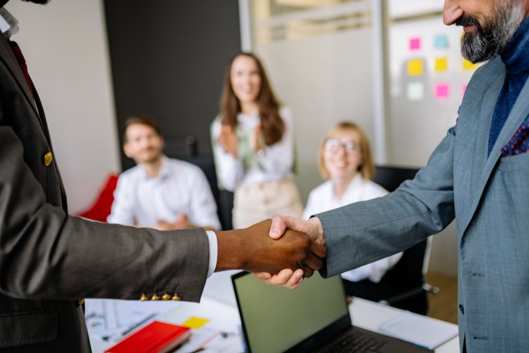Duas pessoas apertando mãos, fechando uma parceria ou negócio. Créditos: Pexels